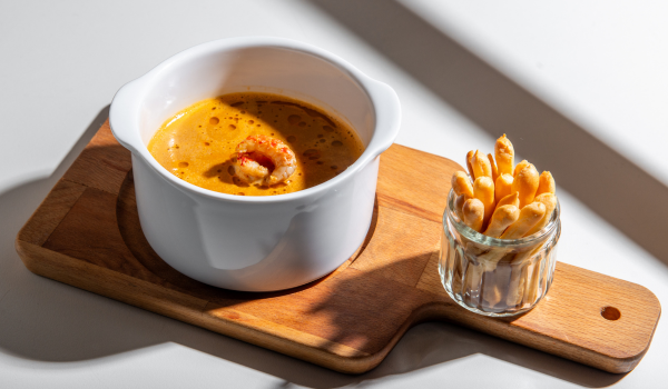 velvety crayfish soup with saffron oil and puff pastry grissini